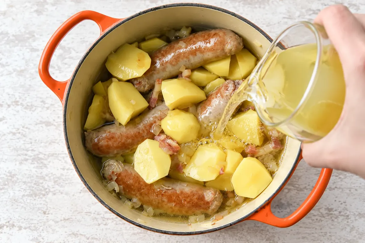 Broth being added to the ingredients of the Dublin coddle.